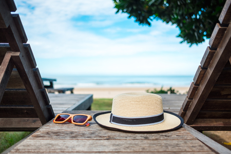 summer background beautiful beach have sun hat place on wood table near sea and blue skyの写真素材