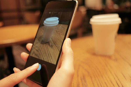 technology background hand of woman using mobile phone take coffee glass photo with copy space....