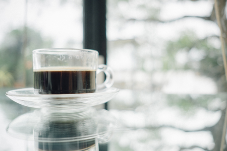 food background cup of coffee on table in restaurant with glass window are backdropの写真素材