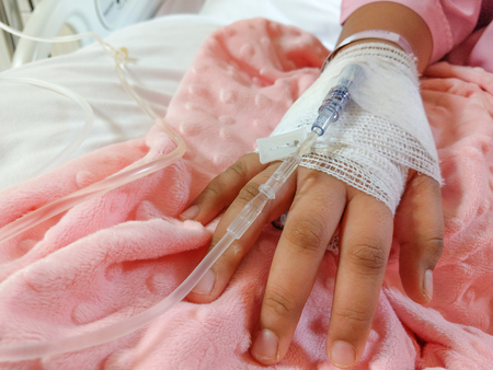 healthcare background closeup hand of child patient have resting and treatment on bed in hospital roomの写真素材