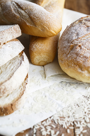 Fresh baked bread and sliced bread on rustic wooden tableの写真素材
