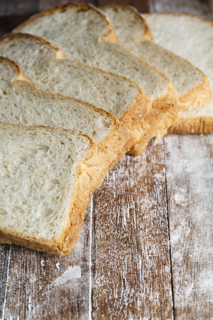 Fresh baked bread and sliced bread on rustic wooden table