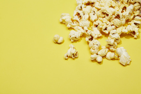 Full of popcorn in classic striped box on color background