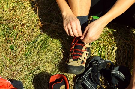 men tying the knot on trekking bootsの写真素材