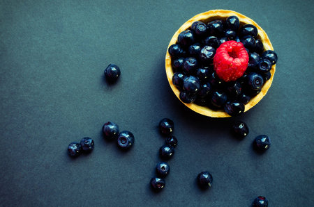 blueberry and raspberry tart on dark backgroung still lifeの写真素材