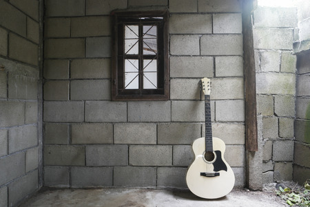 white guitar and one window in the old room.の写真素材