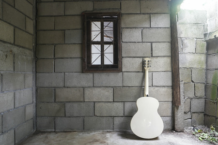 white guitar and one window in the old room.の写真素材