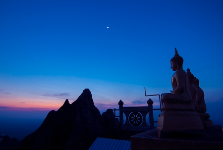 Buddha on the hill top in the early morning at Wat Tam Sau or Tiger cave templeの写真素材