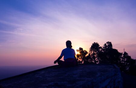 silhouette lady meditation on the hiltop at Tiger cave or Wat Tam Sua Krabi Thailandの写真素材