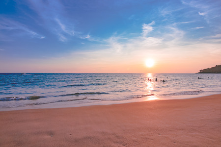panorama beach sunset with the traveler swimming in the seaの写真素材
