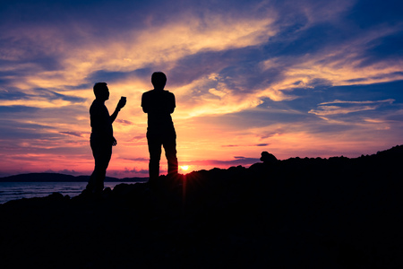 Two man talking and standing on the clift during travel at Krabi Aonang, Thailand and see panorama beach sunset or sunriseの写真素材