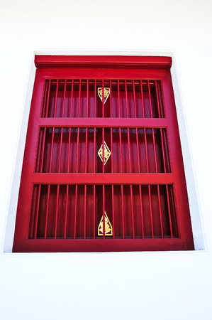 red thai style window on white wall