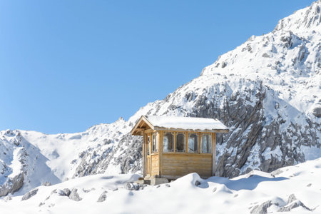 Mountain hut in the snow on the background of a blue skyの写真素材