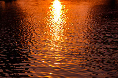 Water surface ripple texture background in sunset