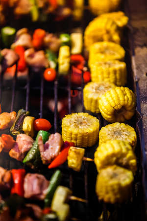 Homemade grilled Barbecue skewers meat kebabs with vegetables on flaming grillの写真素材