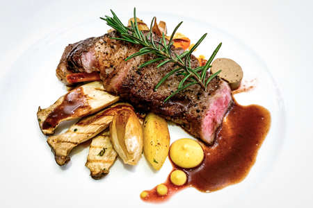 Grilled beef  steak with herbs on white plate