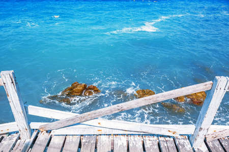 Old white wooden bridge walkway over sea beach, Sang Wan beach Koh Larn, Pattaya, Thailandの写真素材