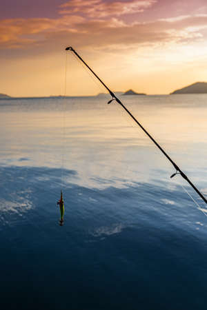 silhouette of Fisherman fishing on the beach at sunsetの写真素材
