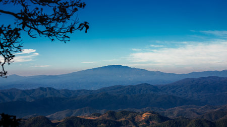 Landscape of beautiful valley mountains in cloudy day with sun rays at sunseの写真素材
