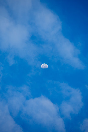 crescent moon in blue sky with cloudsの写真素材