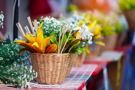 woman hand holding flower basket Chiang Mai City Pillar Inthakin Festival, crowd buddhist people make merit with flowers in Wat Chedi Luangの写真素材