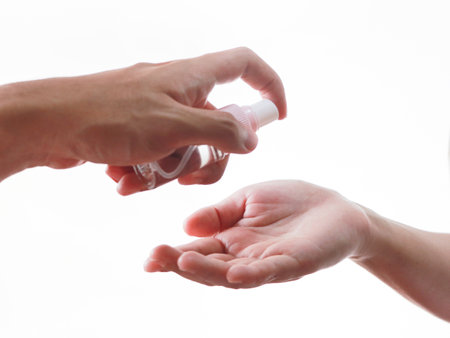 Man applying hand sanitizer on woman's hand isolated on white background