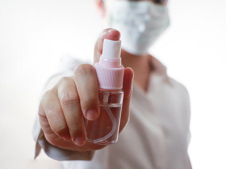 Closeup of a female doctor holding a bottle of hand sanitizerの写真素材