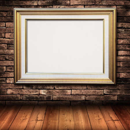gold picture frame on brick wall and wood floorの写真素材
