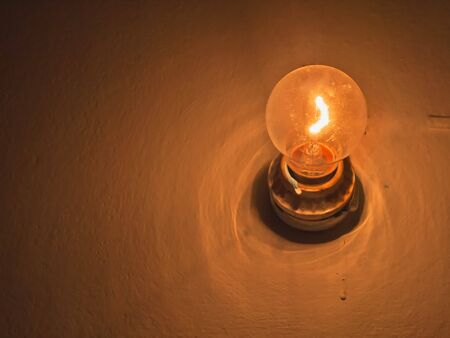 Traditional light bulb on wallの写真素材