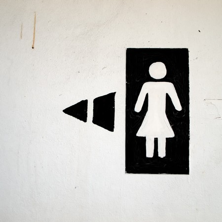 black and white woman toilet sign painting on wallの写真素材