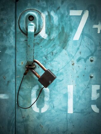 Old Lock key on the green iron gatesの写真素材