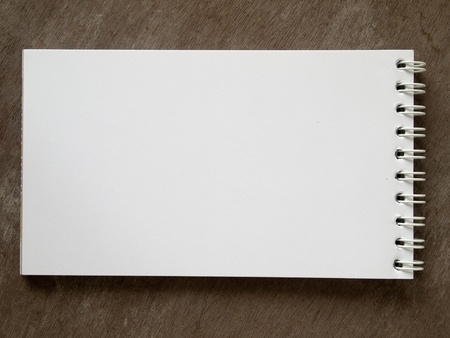 Long blank white note book horizontal on wood table backgroundの写真素材