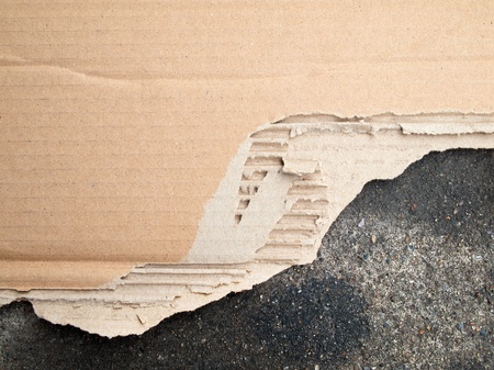 Torn brown cardboard paper on floorの写真素材
