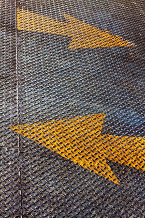 Two Yellow arrows Piant on steel floor palteの写真素材