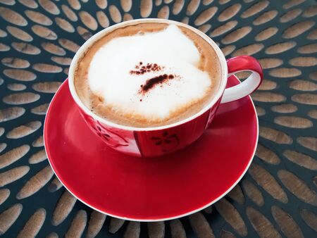 Red cup of coffee and Cappuccino on wood tableの写真素材