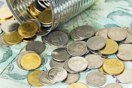 Thai banknotes and coins flowing out of the canの写真素材