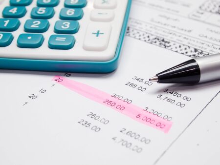 Green calculator black pen and list of billの写真素材