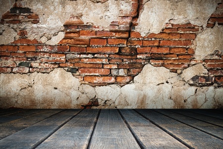 Cracked plaster of old brick wall and wood floorの写真素材
