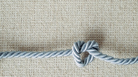 Light gray Rope tie a heart shape On cream fabricの写真素材