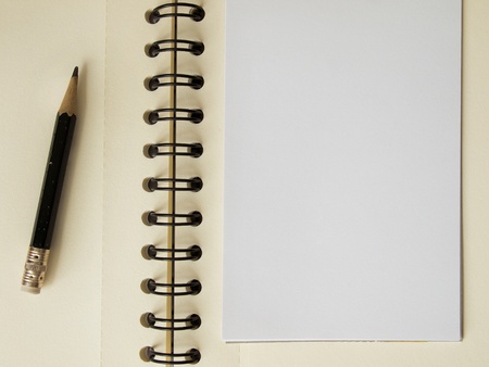 White note paper and black pencil on notebook