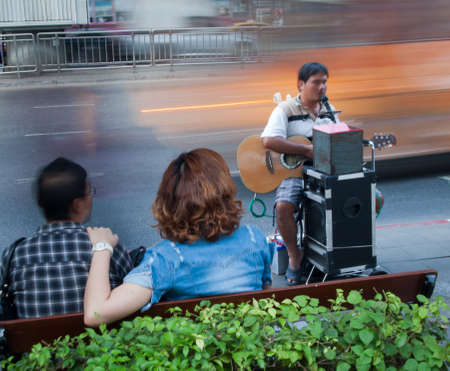 Bangkok, Thailand - December 22 : Playing guitar, singing blind beggar in the street car on December 22nd 2011のeditorial素材