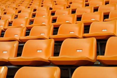 Orange Empty plastic seats at stadium open door sports arenaのeditorial素材