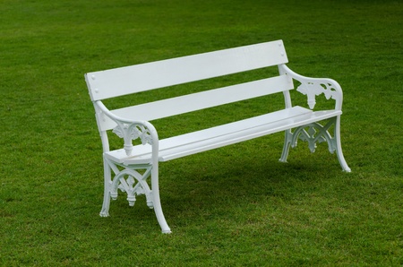 White Bench on green lawn in the gardenの写真素材