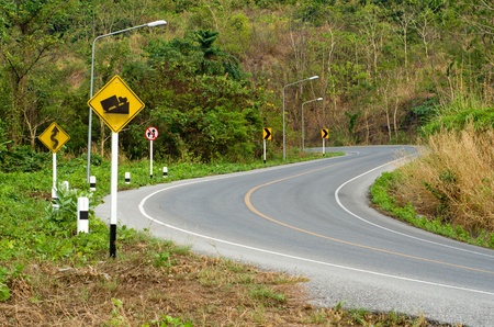Country curves  road up the mountain and yellow signの写真素材