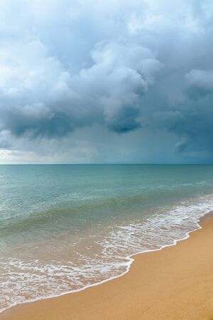Storm cloud the sea and white wave on sandy beachの写真素材