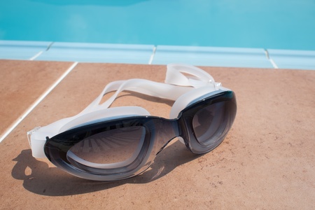 Black Goggles Glasses for Swimming on side of Poolの写真素材