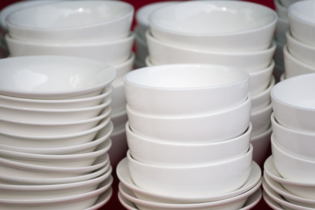 Group of White ceramic bowls stacked for sale in marketの写真素材