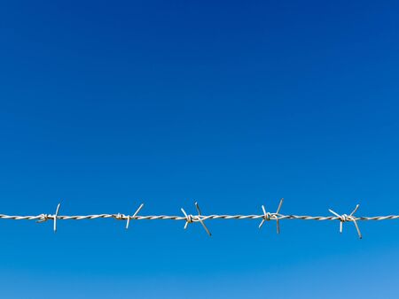 White Razor Wire Line and blue sky Backgroundの写真素材