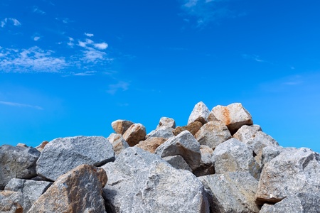 Big pile of gray rock Blue sky and White cloudの写真素材