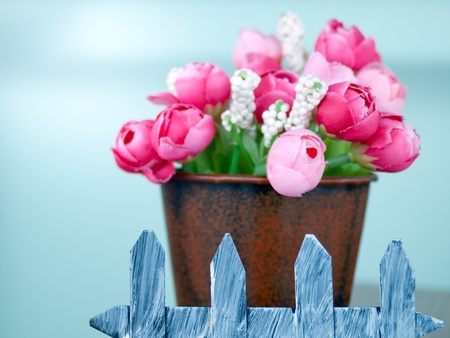 Fake plastic tiny pink and red roses in a brown potの写真素材